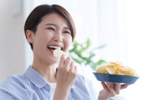 ポテトチップスを食べる女性