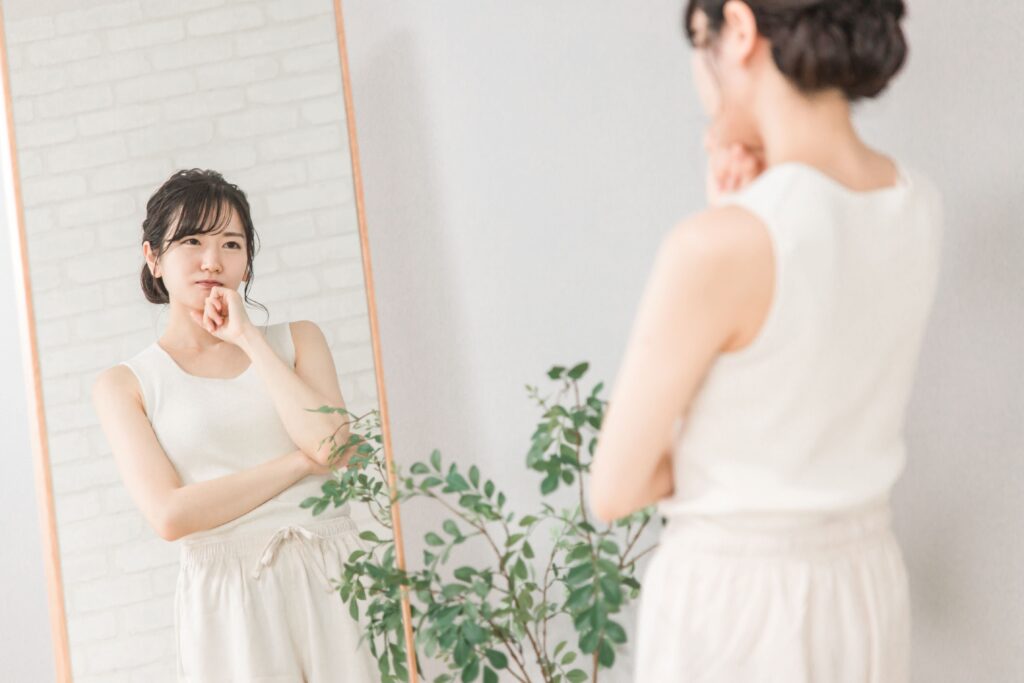 鏡の前で悩む女性の写真